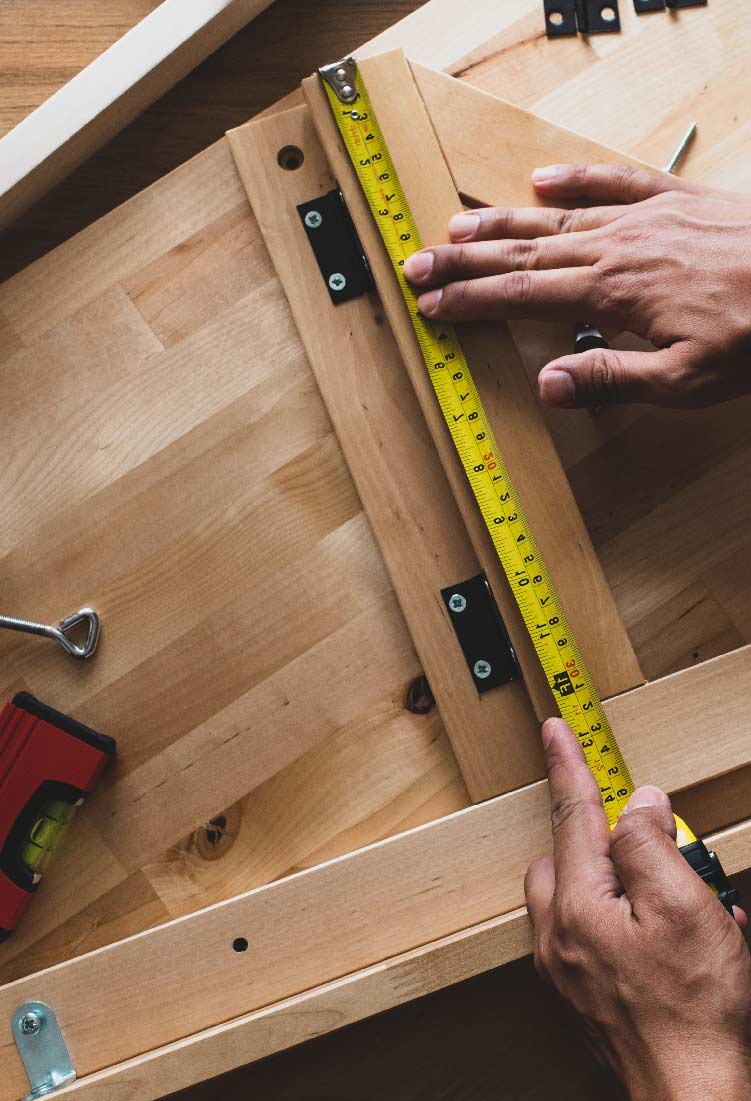 Man measuring planks with measuring tape
